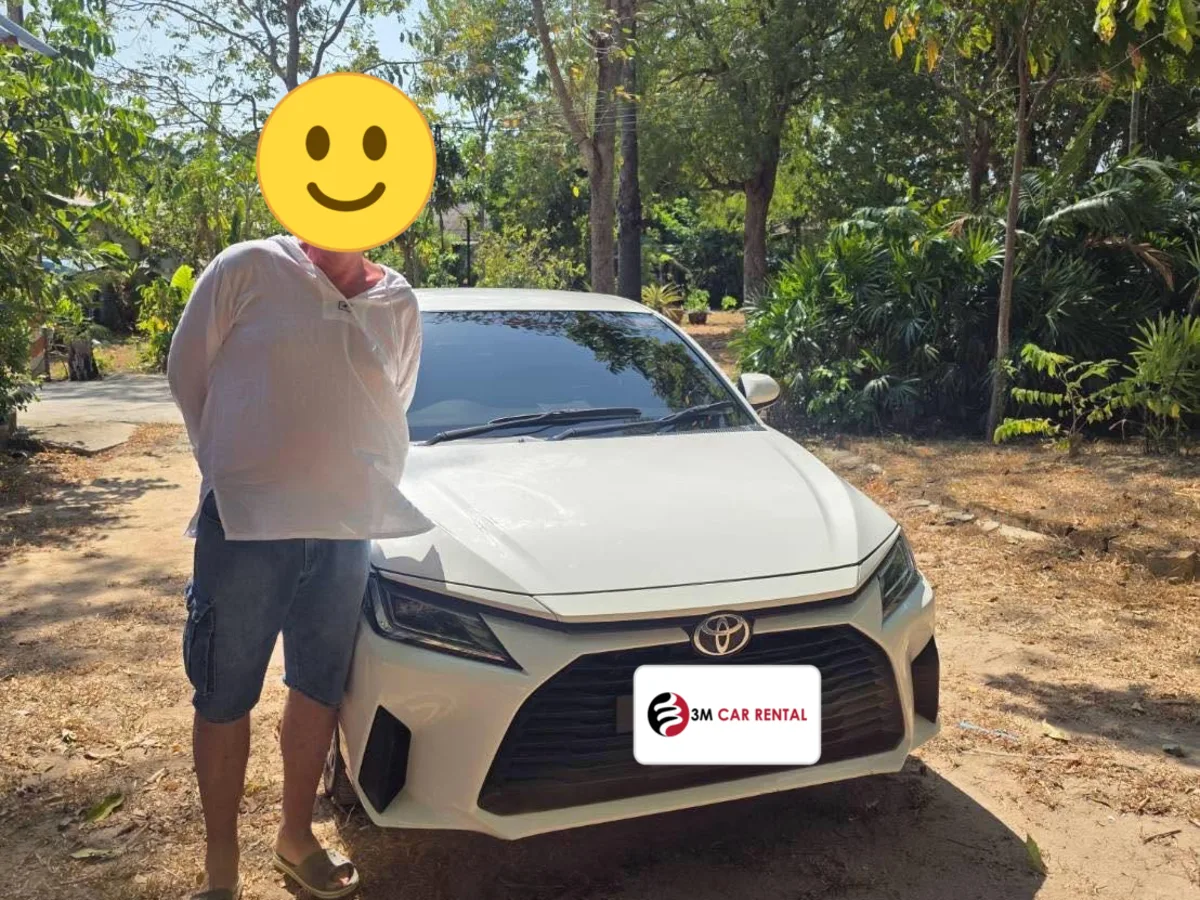 Guest with a white Toyota Yaris Ativ rental car under Phuket trees